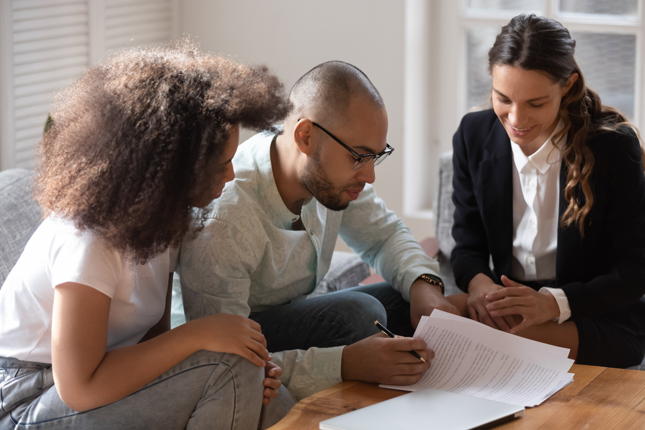 African couple meet with notary or lawyer discuss prenuptial agreement, before sign rental tenancy contract legal document pages spouses read conditions, banker and clients loan lease mortgage concept
